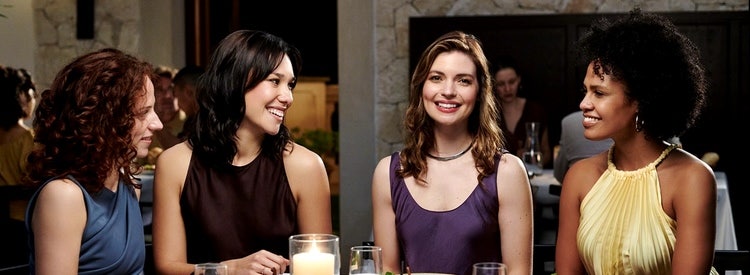 Actor portrayal of a group of women sitting at dinner together