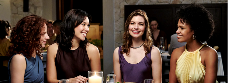 Actor portrayal of a group of women sitting at dinner together